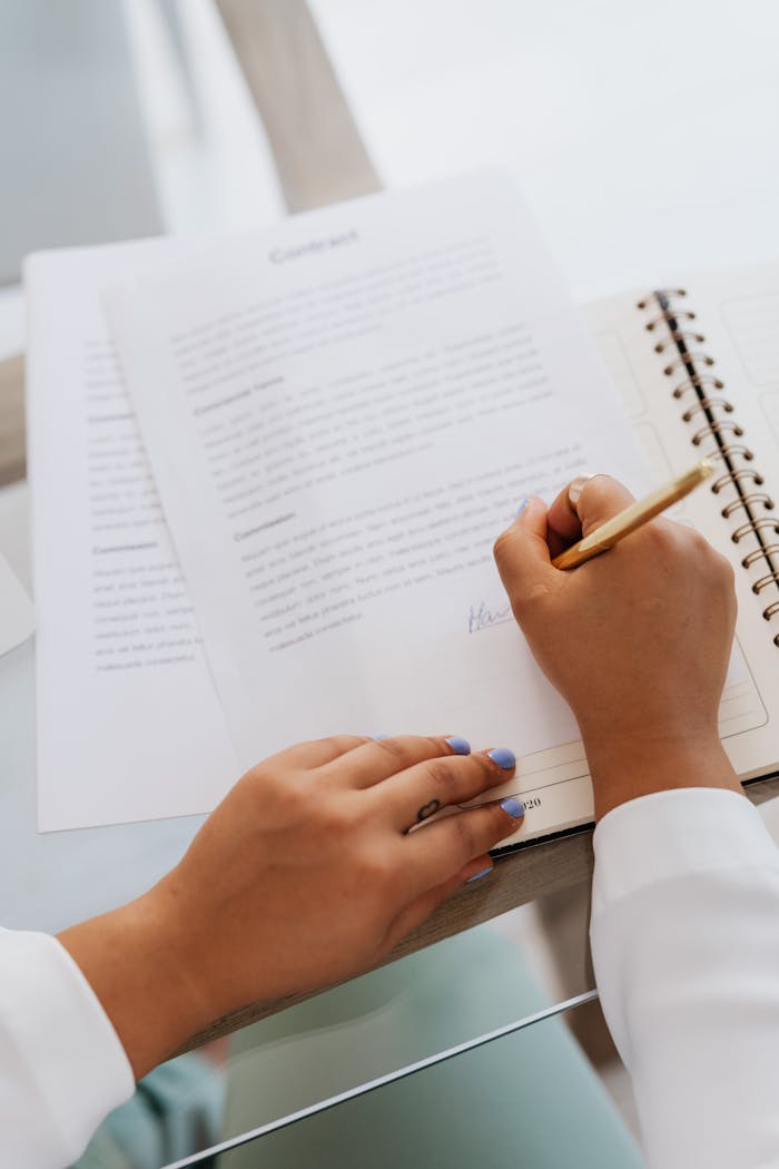 why-choose-us Woman signing a contract with a gold pen, focus on hands and document.